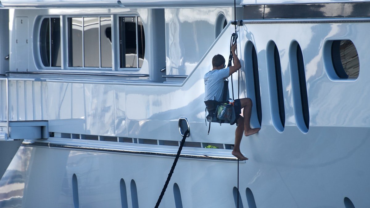 Marine surveyor inspecting a yacht hull out of the water